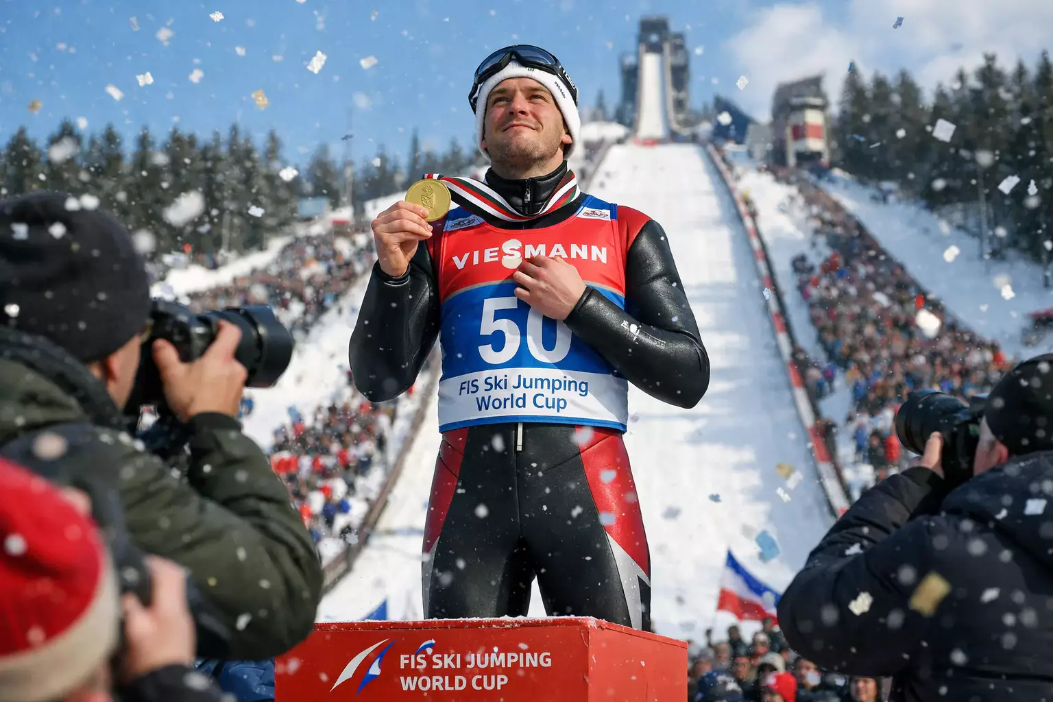 Skoczek narciarski z medalem na podium podczas ceremonii dekoracji